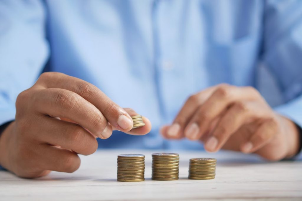 Persona Apilando Monedas Sobre Una Mesa