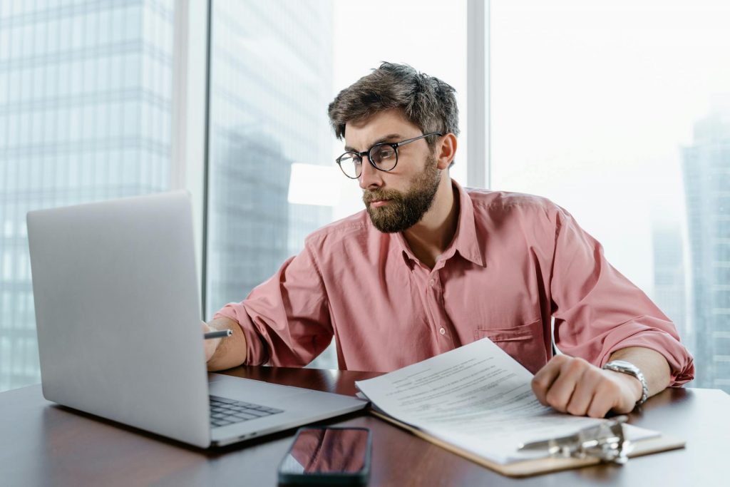 Hombre Con Camisa Roja Y Gafas Usando Macbook