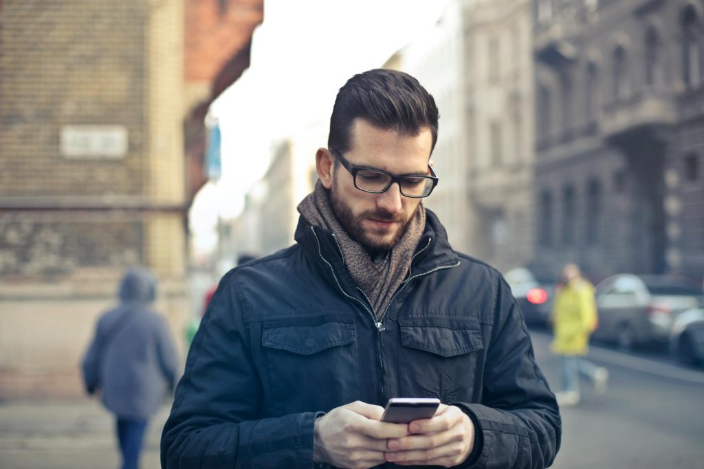 Uomo Tiene Smartphone Tra Edifici In Cemento