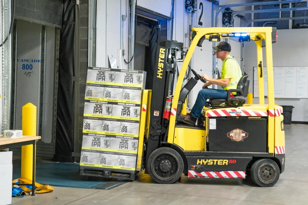 Man Ridinga a Yellow Forklift Lifting Boxes