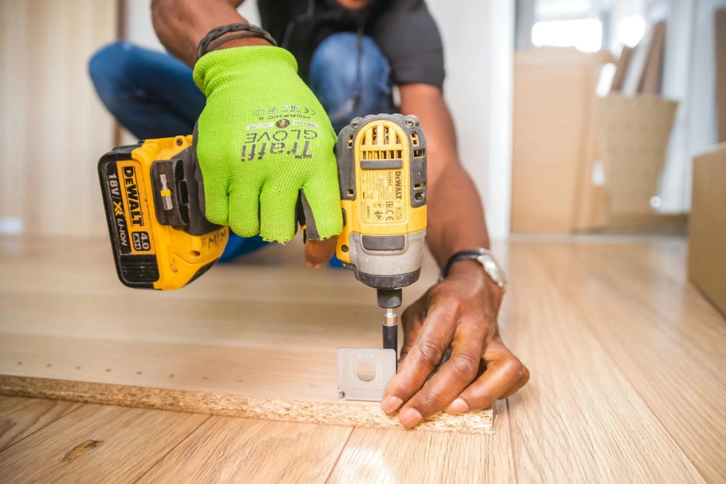 Person Using Cordless Impact Driver on Board